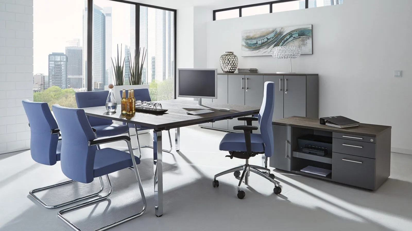 Büroraum mit Konferenztisch, blauen Stühlen und Sideboard